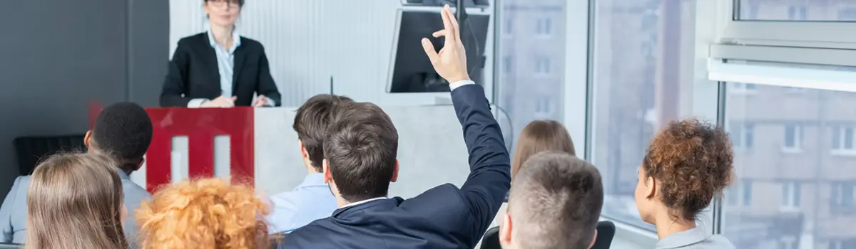 FAQ2 copy man in a suit raising his hand at a press conference